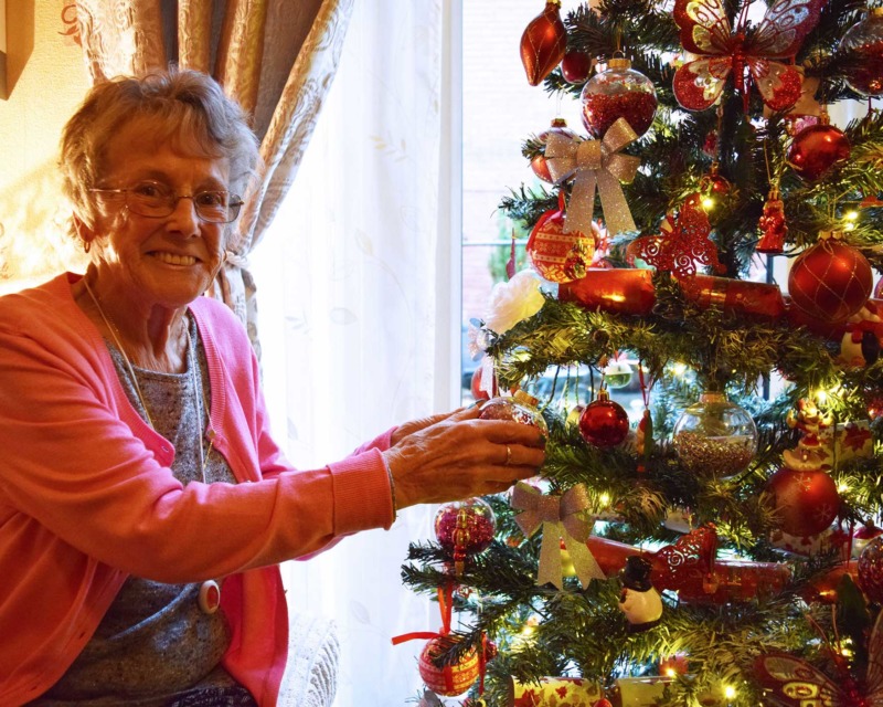 Sheila Wilkinson next to Christmas Tree